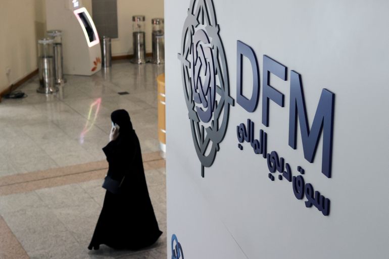 A woman walks through the Dubai Financial Market after Joe Biden won the U.S. presidency, in Dubai, United Arab Emirates November 8, 2020. REUTERS/Christopher Pike
