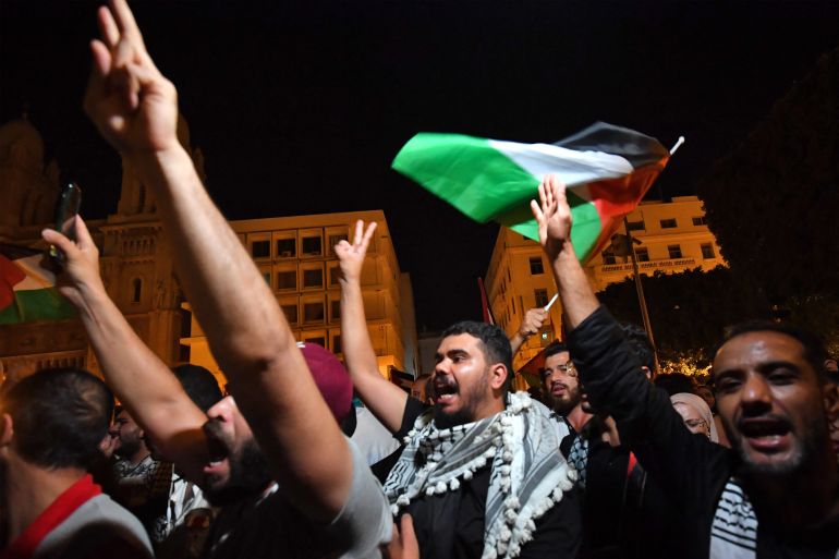 Tunisian protestors shout slogans and wave Palestinian national flags during an anti-Israel demonstration in front of the French ambassy in Tunis on October 17, 2023. - Thousands of angry protesters gathered outside the French embassy in Tunisia on October 17, also denouncing the US, after a strike on a Gaza Strip hospital killed at least 200 people. The health ministry in Hamas-ruled Gaza said at least 200 people died in the strike, which it blamed on Israel. The Israeli army, however, said a misfired rocket from Islamic Jihad militants was responsible. (Photo by FETHI BELAID / AFP)