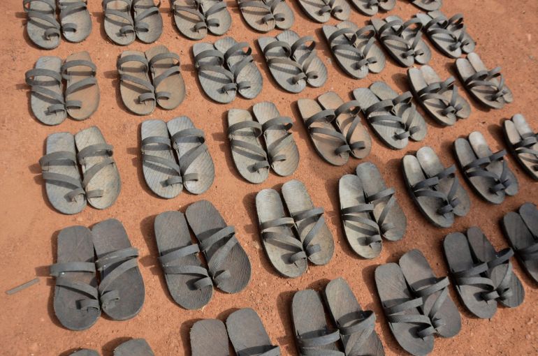 Article: Footwear crafted from recycled rubber tires are displayed on the ground in Wau, South Sudan, Friday, June 13, 2025. (AP Photo/Michael Atit)