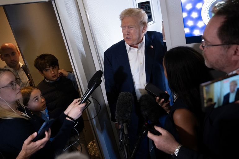 Deputy Chief of Staff Stephen Miller (L), along with US President Donald Trump's grandchildren Chloe and Spencer Trump, listen as the president speaks to reporters aboard Air Force One over the United Kingdom on July 29, 2025, as he returns to Washington following a trip to Scotland.