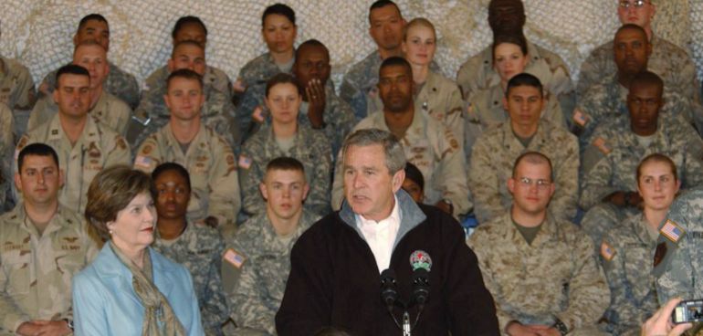 BAGRAM AIRFIELD, AFGHANISTAN - MARCH 1: In this handout photo provided by the U.S. Army, U.S. President George W. Bush speaks to soldiers as first lady Laura Bush listens during a surprise visit by the president March 1, 2006 at Bagram Airfield, Afghanistan. (Photo by Brian Schroeder/U.S. Army via Getty Images)