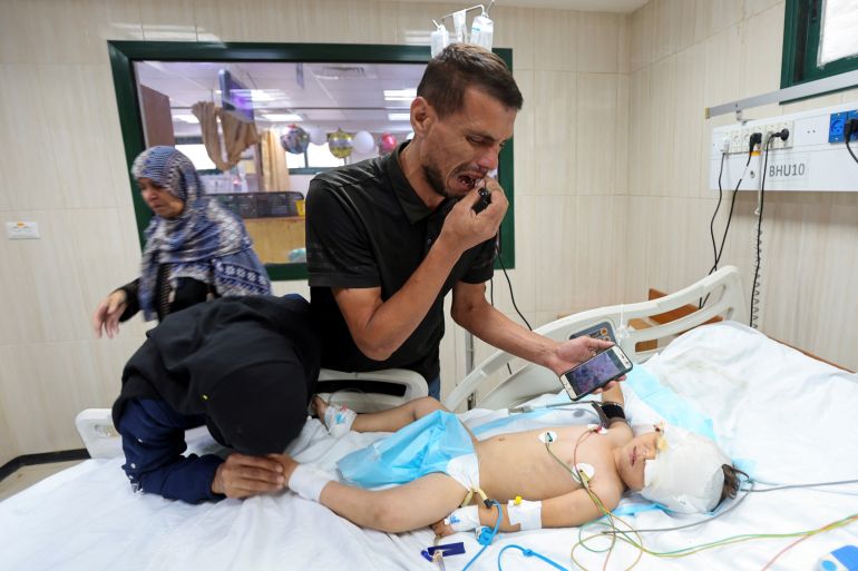 Palestinian parents Hatem and Iman Al-Nouri, who lost two of their children, Omar and Amir, in the July 10 Israeli strike while they were queuing for supplements near a medical center, react as they accompany their son Siraj, who was wounded in the same strike, at Al-Aqsa Martyrs Hospital in Deir al-Balah, in the central Gaza Strip, July 14, 2025. REUTERS/Ramadan Abed