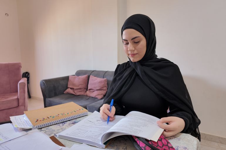 الطالبة آية حمدان تابعت دراستها في ثانوية أنصار الرسمية بعد أن أرغمت على ترك بلدتها ميس الجبل بسبب الحرب (الجزيرة)