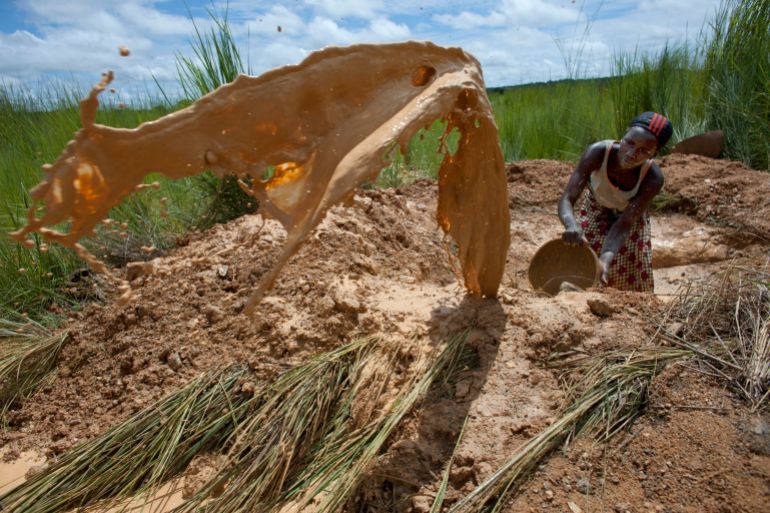 An artisanal gold miner tosses a bucket of mudwater to clear the way for work on a small-scale gold mine in Kalana August 26, 2012. Nearly 10,000 annual tourists visited Djenne, a UNESCO World Heritage-listed town, in previous years. Since Mali's coup d'etat in late March, after which Islamist rebels took control of the country's northern two-thirds, less than 20 tourists have come to Djenne, according to the local tourism board. Picture taken August 26, 2012. REUTERS/Joe Penney (MALI - Tags: TRAVEL BUSINESS SOCIETY RELIGION)