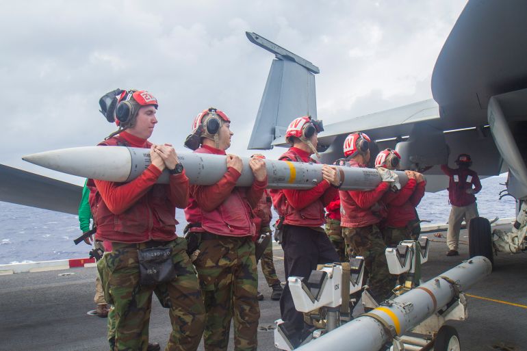AT SEA - NOVEMBER 222: In this handout photo provided by the U.S. Navy, Aviation Ordnancemen prepare to load an AIM-120 missile onto an F/A-18E Super Hornet from the Royal Maces of Strike Fighter Squadron (VFA) 27 on the flight deck of the aircraft carrier USS George Washington (CVN 73). George Washington and its embarked air wing, Carrier Air Wing (CVW) 5, provide a combat-ready force that protects and defends the collective maritime interest of the U.S. and its allies and partners in the Indo-Asia-Pacific region. (Photo by Ricardo R. Guzman/U.S. Navy via Getty Images)