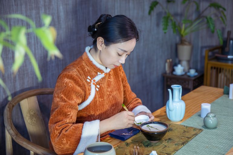Tea ceremony master uses tea powder to paint on tea in bowl