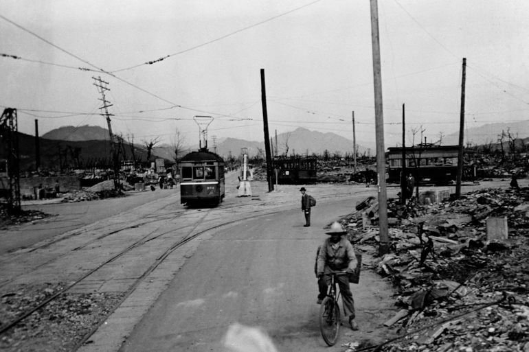 A trolley still operates and a few civilians make their way along roads passing through the ruins of Hiroshima (Photo by © CORBIS/Corbis via Getty Images)