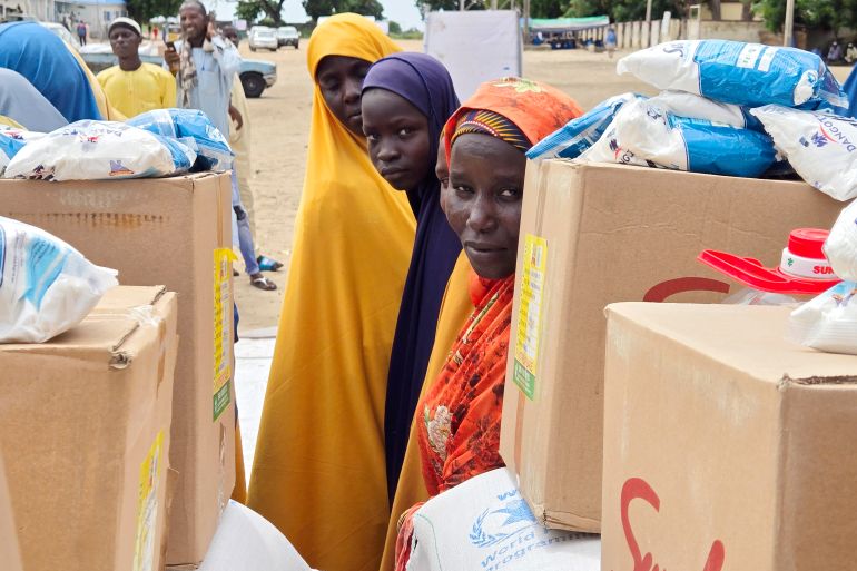 FILE - People wait to receive food donations from the United Nations World Food Program in Damasak, northeastern Nigeria, Oct. 6, 2024. (AP Photo/Chinedu Asadu, File)
