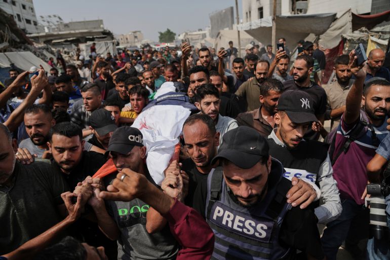 Palestinians carry the body of Al Jazeera correspondent Anas al-Sharif, who, along with other journalists, was killed in an Israeli airstrike, during his funeral outside Gaza City's Shifa hospital complex, Monday, Aug. 11, 2025. (AP Photo/Jehad Alshrafi)