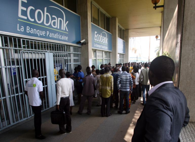 Customers crowd the entrance to a branch of Ecobank in the Plateau business district of Abidjan, Ivory Coast Wednesday, Feb. 16, 2011. Another bank says it has closed its doors amid a political crisis in Ivory Coast, as residents in the commercial hub lined up at banks to try to withdraw their savings amid rumors of a cash shortage. British bank Standard Chartered confirmed Wednesday that it had suspended its operations in Ivory Coast, joining two other banks and the regional stock exchange.(AP Photo/Emanuel Ekra)