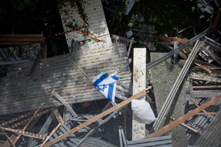 TEL AVIV, ISRAEL - JUNE 22: An Israeli flag lies among debris at the site of an Iranian airstrike on June 22, 2025 in the Ramat Aviv neighborhood Tel Aviv, Israel. Israel was hit with a fresh wave of aerial attacks by Iran after the US entered the war overnight and bombed several Iranian nuclear sites. (Photo by Dima Vazinovich/Getty Images)