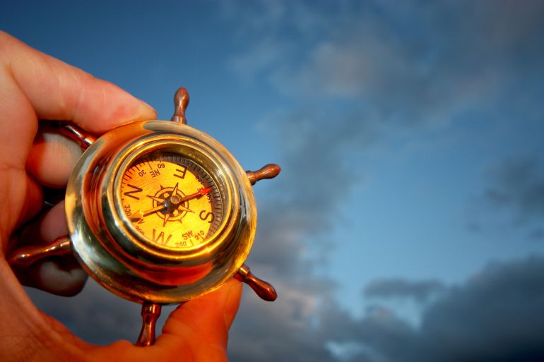 Hand holding compass.