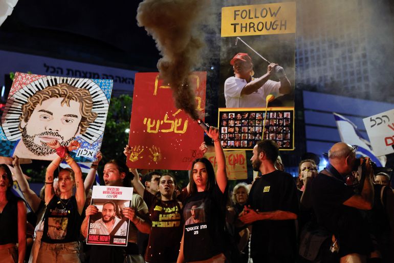A demonstrator holds a smoke flare, during a protest to demand the immediate release of hostages held in Gaza since the October 7, 2023, attack on Israel by Hamas and to end the war, in Tel Aviv, Israel, August 2, 2025. REUTERS/Ammar Awad