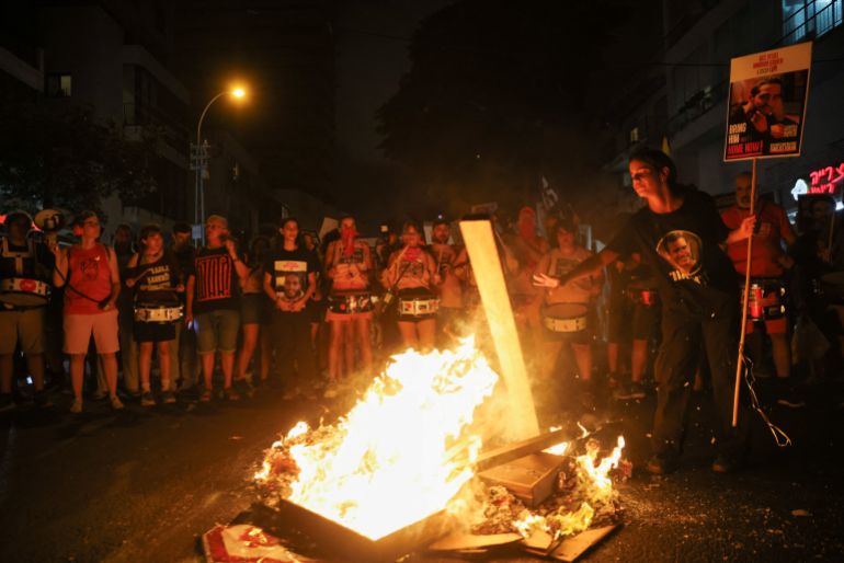 Demonstrators stand around a fire blocking a road, during a protest, after families of hostages have called for a nationwide strike to demand the return of all hostages and an end to the war in Gaza, in Tel Aviv, Israel August 17, 2025. REUTERS/Shir Torem