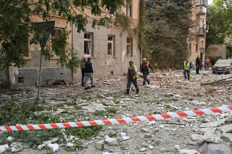Communal workers pass by an apartment building hit by a Russian drone strike, amid Russia's attack on Ukraine, in Lviv, Ukraine August 21, 2025. REUTERS/Stringer