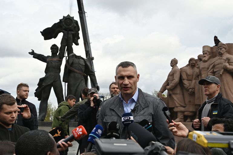 Kyiv mayor Vitali Klitschko speaks to journalists in front of the Soviet monument to Ukraine-Russia friendship dismantled by workers in Kyiv on April 26, 2022, amid Russian invasion of Ukraine. Authorities in Kyiv on April 26, 2022 began demolishing a monument symbolising historic ties between ex-Soviet Ukraine and Russia, AFP correspondents reported, more than two months after Moscow's troops invaded Ukraine. (Photo by Genya SAVILOV / AFP) Related content