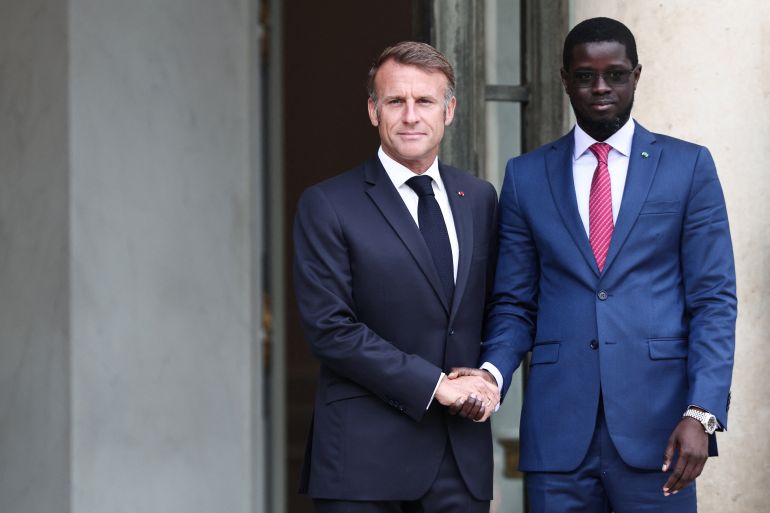 France's President Emmanuel Macron (L) shakes hands with Senegalese President Bassirou Diomaye Faye as they arrive for a meeting at the Elysee Presidential Palace in Paris on August 27, 2025. (Photo by Thibaud MORITZ / AFP)
