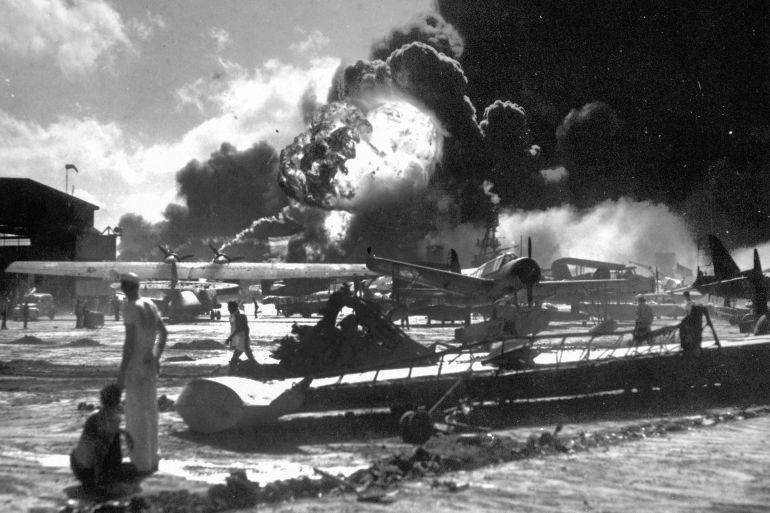 FILE - In this Dec. 7, 1941 photo provided by the U.S. Navy, sailors stand among wrecked airplanes at Ford Island Naval Air Station as they watch the explosion of the USS Shaw, background, during the Japanese surprise attack on Pearl Harbor, Hawaii. More than 2,300 U.S. service members and civilians were killed in the strike which brought the United States into World War II. (U.S. Navy via AP)